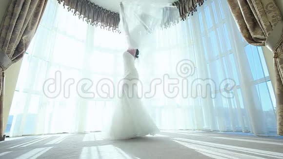 美丽的女性旋转新娘礼服慢动作酒店客房视频的预览图