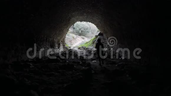 从土耳其苏丹尼萨的古老地下通道走出来的女人隧道尽头的灯光4k视频的预览图