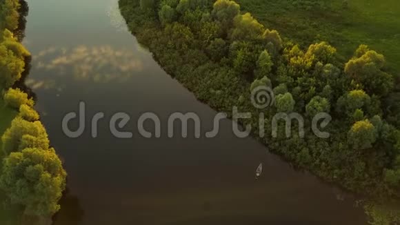 日落时分一个渔夫坐在河上的小船上视频的预览图