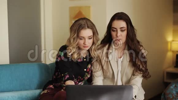 两个漂亮女孩带着笔记本电脑和平板电脑视频的预览图
