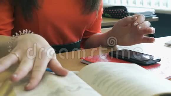 女生坐在书桌前翻阅一本书视频的预览图