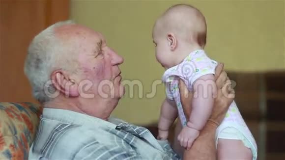 快乐的祖父手里拿着婴儿说话视频的预览图