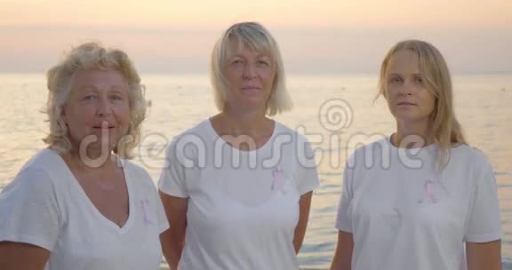 三名妇女戴着粉红色的乳腺癌意识丝带视频的预览图