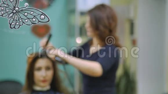 理发师在发廊里用矫直机对漂亮的女人的头发卷曲的波纹视频的预览图