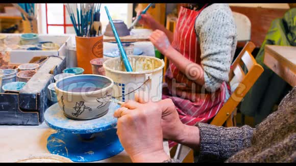 艺术家们在陶器碗上画画视频的预览图