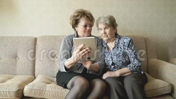 老妇人和她的朋友在看照片视频的预览图