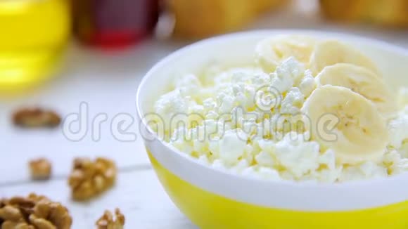 健康的早餐面包屑奶酪和香蕉核桃牛角面包蜂蜜和柠檬果酱在碗里视频的预览图