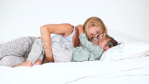 母亲和儿子在床上拥抱和玩耍视频的预览图