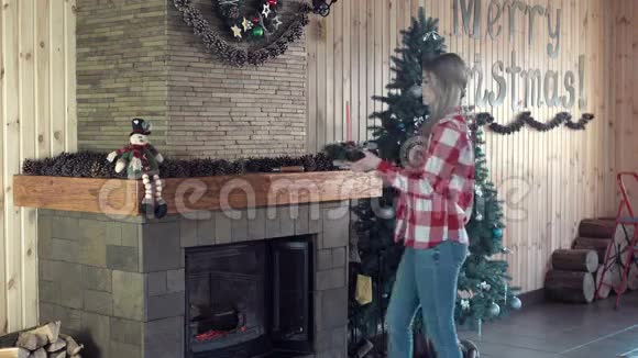 为圣诞节装饰壁炉的女人视频的预览图