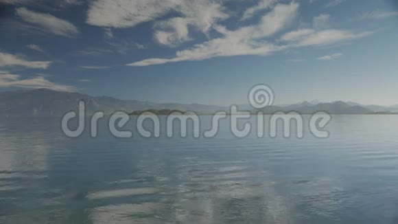 湖景以小浪和小岛丘陵和多云的天空为背景4k视频的预览图