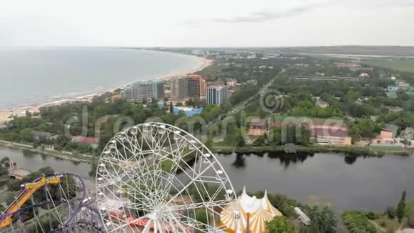 海边的游乐园用无人机观看摩天轮和水上公园从高处射击视频的预览图