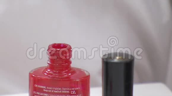 将刷子放入红指甲油瓶中视频的预览图