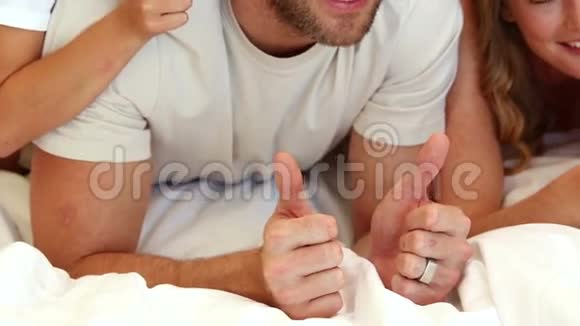 一家人用大拇指在床上玩耍视频的预览图
