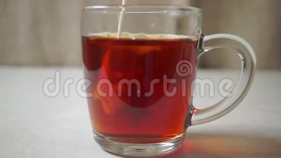 在杯子里的红茶中加入牛奶关上视频的预览图