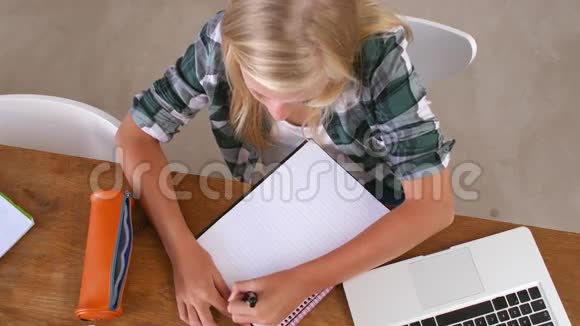 女生在笔记本电脑桌上做作业的俯视图视频的预览图