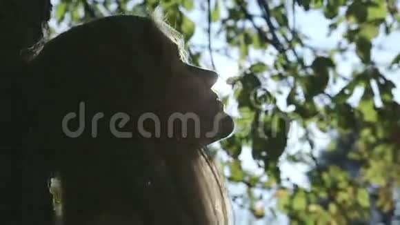 在秋天公园的树下休息的年轻女子视频的预览图
