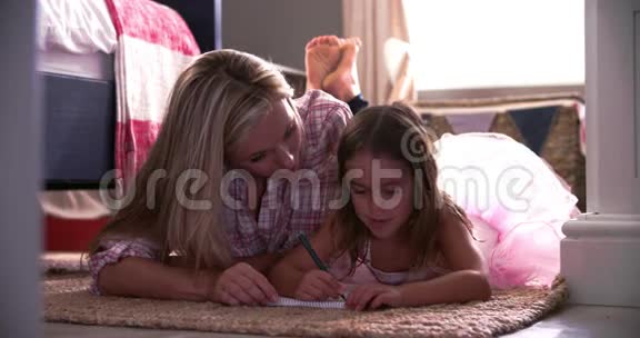 母亲和女儿在卧室练习手写视频的预览图