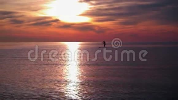 日落的大海日落时分人们在冲浪板上划船海水日落平静的海水视频的预览图