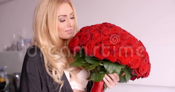穿睡衣的微笑女人拿着玫瑰花束视频的预览图