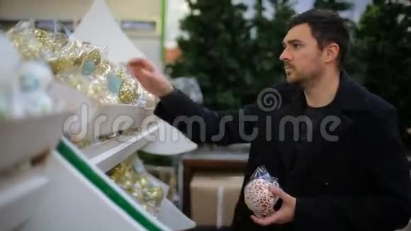 男人在商店里挑选圣诞装饰品视频的预览图