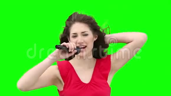 女人一边挥动手臂一边对着麦克风唱歌视频的预览图