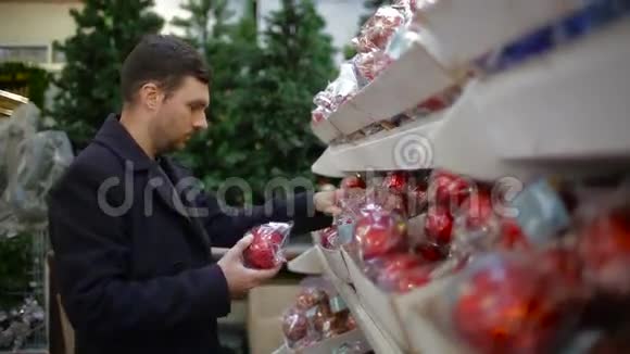 男人在商店里挑选圣诞装饰品视频的预览图