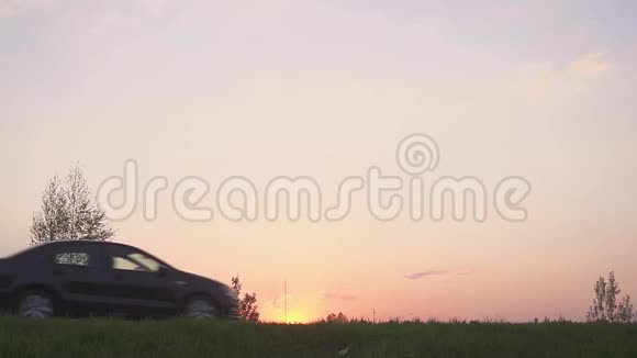 日落时一辆汽车在田野里的剪影路和田野场上的车视频的预览图