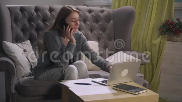 金发美女在智能手机上聊天在图表和笔记本电脑上做笔记视频的预览图