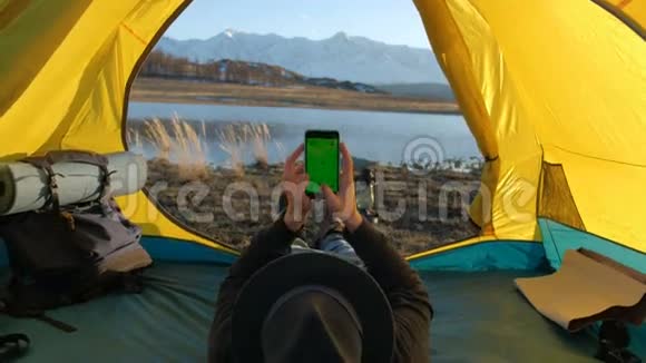贴在帐篷上的太阳能电池板坐在手机旁边的那个人从阳光下收费20s4k视频的预览图