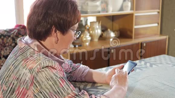 一位老年妇女在手机上写短信她小心翼翼地按在屏幕上发短信视频的预览图