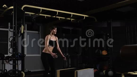 年轻的女运动员在健身房做一个盒子跳跃专注于女人视频的预览图