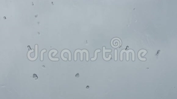 春天的雪积在窗玻璃上视频的预览图