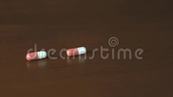 药片以胶囊的形式落在桌子上视频的预览图