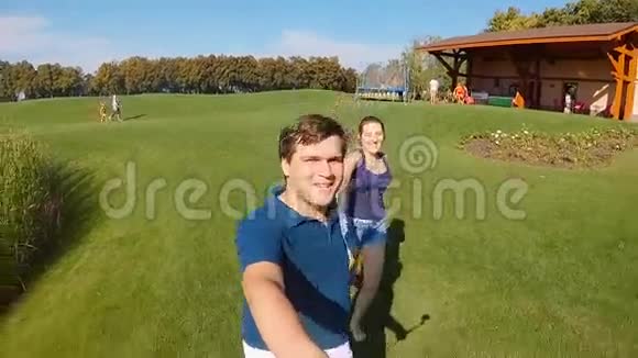 快乐的年轻夫妇牵着手在公园跑步视频的预览图