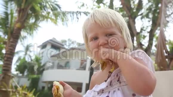 小女孩把香蕉皮还给游泳池附近的妈妈视频的预览图