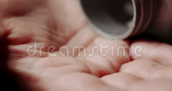 女人把塑料瓶里的白色药片洒在手心视频的预览图