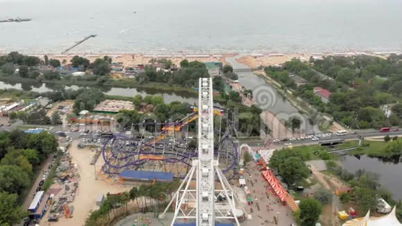 海边的游乐园用无人机观看摩天轮和水上公园从高处射击视频的预览图