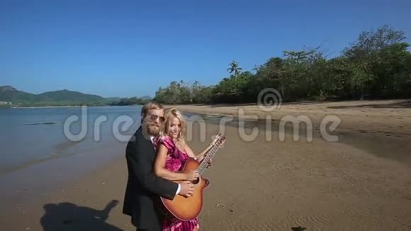 吉他手帮助金发女孩弹吉他然后指出视频的预览图