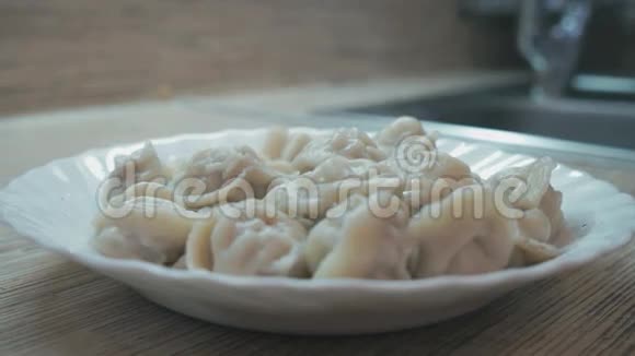 桌子上放着一盘热的自制饺子视频的预览图