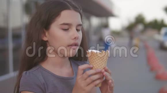 吃冰淇淋的小女孩走在超市旁边的大街上有一种柔软的玩具生活方式视频的预览图
