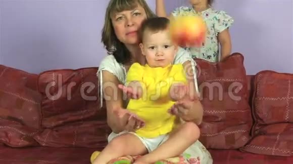 快乐的女人和小孙子一起吃美味的苹果视频的预览图