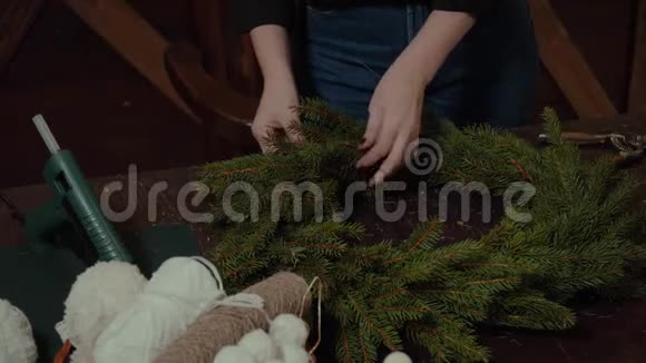 年轻可爱的微笑女设计师准备圣诞常青树花圈圣诞装饰制造商视频的预览图