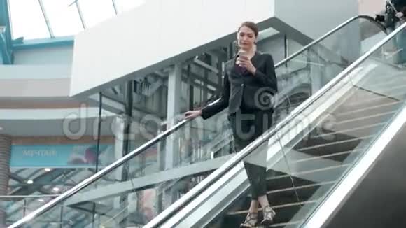 年轻的女商人肖像在自动扶梯上的电话交谈在商场或办公室工作的女商人视频的预览图