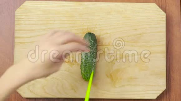 女人在厨房切黄瓜木制木板视频的预览图