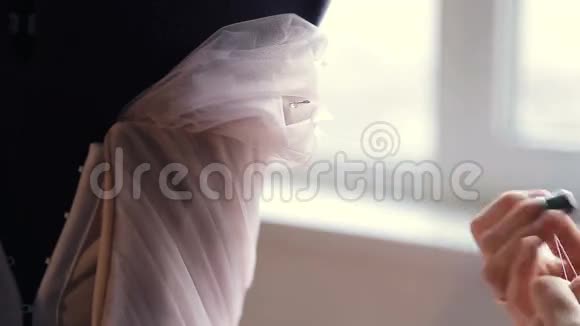 时尚设计师的双手缝制婚纱从花边特写视频的预览图