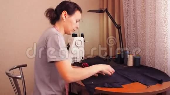 裁缝裁剪布料女孩用剪刀剪布料织物上的刺针视频的预览图