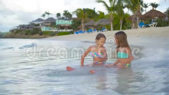 可爱的小女孩在海滩上轻松地在浅水中玩耍视频的预览图