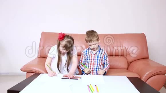 两个可爱的快乐孩子在玩学校用蜡笔画画唐氏综合症的女孩残疾人康复视频的预览图