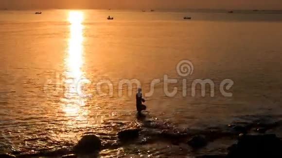 从海上剪影到日落时明亮的太阳路径船的运动视频的预览图