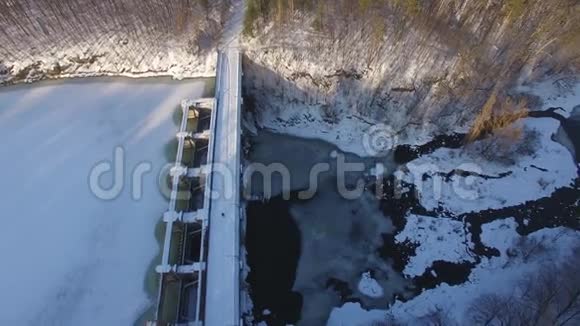 冬天美丽的河流上的空中水坝视频的预览图